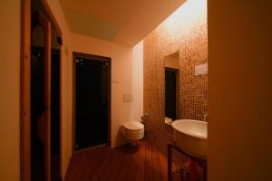 イーゾラ・ロッサにあるHoliday home Isola Rossaのバスルーム(白いトイレ、シンク付)
