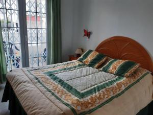 ein Bett mit einer Decke und Kissen darüber in der Unterkunft Manuel in Torrevieja