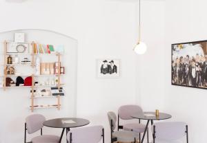 two tables and chairs in a room with white walls at Kai 36 - Hotel zwischen Fels und Fluss in Graz