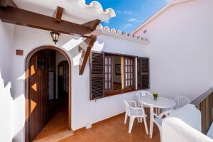 a balcony with a table and chairs in a house at Apartamentos Son Bou Gardens By MENORCARENTALS in Son Bou