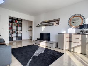 uma sala de estar branca com uma televisão e um sofá em Nestor&Jeeves - SUNSET TERRACE - Central - Free parking - Top floor em Nice