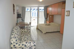 a living room with a bed and a couch at Monolocale Rosburgo 2 in Roseto degli Abruzzi
