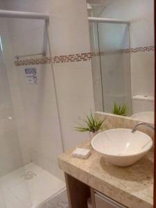 a bathroom with a sink and a shower at Pousada do Maninho in Penha