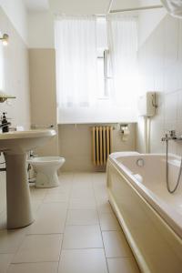 a white bath tub sitting next to a white toilet at UniHo Hostel in Pavia