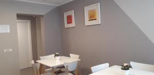 a dining room with two tables and white chairs at City Hotel Bucharest in Bucharest