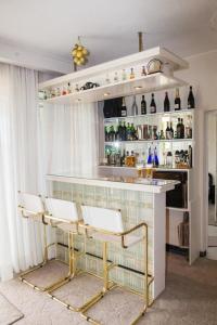 - un bar avec deux chaises et un comptoir avec des bouteilles dans l'établissement Niki seaview apartment, à Pórto Ráfti