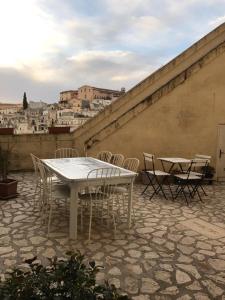 a table and chairs on a patio with a view of a city at B&B La Corte in Matera