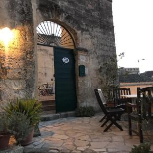 a green door in a stone building with a table at B&B La Corte in Matera