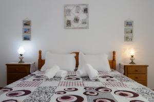 een slaapkamer met een bed met een deken erop bij Figueira Coast View Apartment in Figueira da Foz