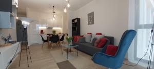 uma sala de estar com um sofá, cadeiras e uma mesa em Central Apartments Ogrody 1 & Parking em Gdansk