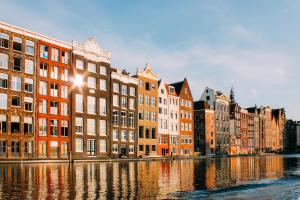 uma linha de edifícios junto a um rio em A Century old Townhouse em Amsterdã