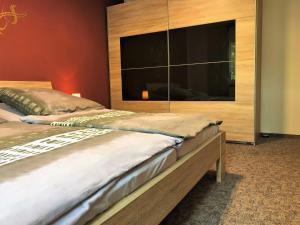 a bedroom with a large bed and a large tv at Ferienhaus am Wiesenweg in Hosena +20 photos