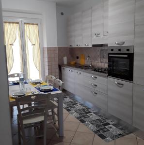 a kitchen with a table and a table and chairs at Casa vacanze GALA in Fiumicino