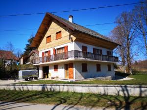 een wit huis met een balkon en een vrachtwagen ervoor bij villa des cascades du hérisson in Bonlieu