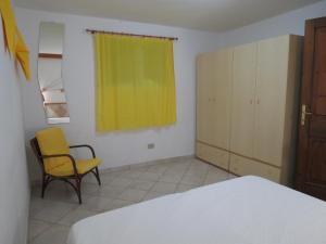 アルバタックスにあるBaia di Portu Frailisのベッドルーム1室(ベッド1台、椅子、窓付)