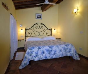 a bedroom with a bed with a blue and white bedspread at Casa Vacanze Oliviera Pienza in Pienza