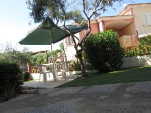 アルバタックスにあるBaia di Portu Frailisの庭の傘付きテーブル