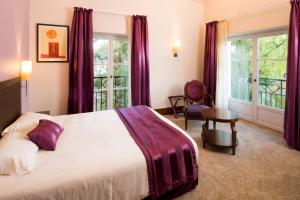 a bedroom with a large bed with purple curtains at Le Clos Rebillotte in Luxeuil-les-Bains