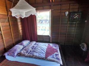 a bedroom with a bed in a room with a window at Molyka Lodge in Banlung