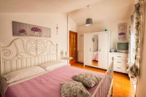 una camera con un letto e una coperta rosa di B&B Borgo Antico a Papasidero