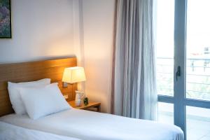 a hotel room with a bed and a window at Porto Platanias Village Resort in Plataniás