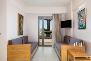 a living room with two couches and a table at Porto Platanias Village Resort in Plataniás