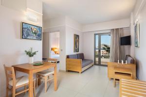 a living room with a table and a dining room at Porto Platanias Village Resort in Plataniás
