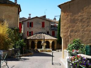 a building with a fountain in the middle of a courtyard at Chambre d'hôtes Villa Chênes-Pierres in Mollans-sur-Ouvèze
