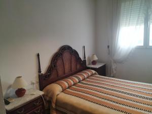 1 dormitorio con 1 cama con cabecero de madera y ventana en Antolin Guest House, en Minaya