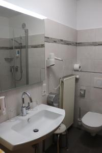 ein Bad mit einem Waschbecken und einem WC in der Unterkunft Weinstube Pension Moselblümchen in Zeltingen-Rachtig