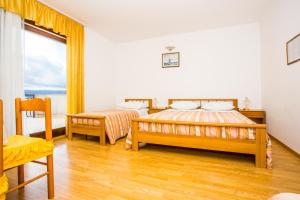 a bedroom with two beds and a window at Apartmani Pava in Omiš