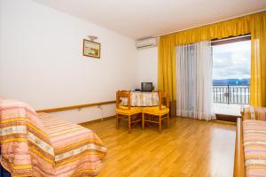 a bedroom with a bed and a desk and a window at Apartmani Pava in Omiš