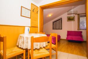 a dining room with a table and chairs and a couch at Apartmani Pava in Omiš