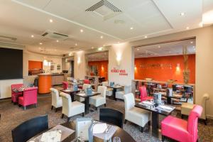 a restaurant with tables and chairs and a counter at Le Clos Rebillotte in Luxeuil-les-Bains