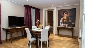 a dining room with a table and a painting at Duca di Sarro le Suites in Catania