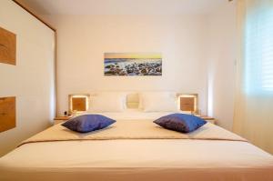 a bedroom with a large bed with two pillows at Apartments Ranko in Zavalatica