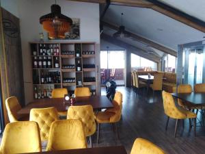 a dining room with yellow chairs and a table at Atlas City Center Hotel in Prilep