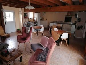 a living room with a table and chairs and a kitchen at La Parisiere in Gavray