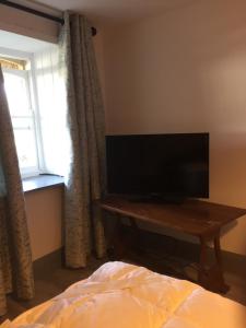 a bedroom with a tv on a table next to a window at Bridge Cottage in Cork