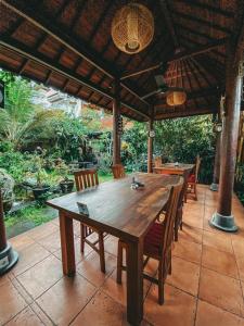ein Holztisch und Stühle auf einer Terrasse in der Unterkunft Villa Cilinaya Ubud in Ubud
