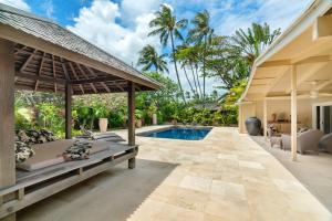 an outdoor patio with a pool and a house at Kailua Beachside home in Kailua