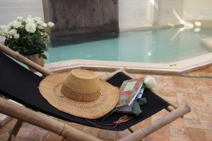 a straw hat sitting on a chair next to a swimming pool at Riad Spa Dar Nimbus in Marrakech
