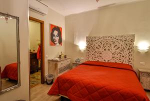 a bedroom with a red bed and a mirror at Ca' del Cinema B&B in Venice