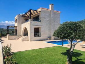 a large house with a swimming pool in front of it at Levanda Luxury Stone Villa in Kalyves