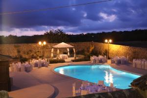 a wedding venue with a swimming pool with chairs and a tent at Agriturismo Baglio Calanchi in Modica