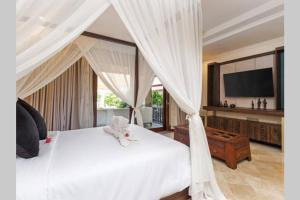 - une chambre avec un lit blanc et une télévision dans l'établissement Villa Deh Simba at Oberoi, à Seminyak