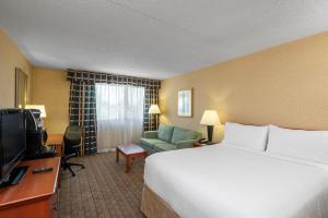 a hotel room with a bed and a television at Amenida Residences, Calgary in Calgary