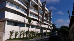 a building with palm trees in front of it at Dubai residência in Cabo Frio