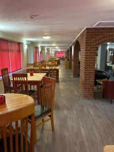 un restaurante con mesas y sillas de madera y una pared de ladrillo en Beaufort Park Hotel, en Mold