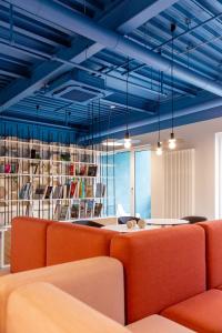 an office with blue ceilings and orange furniture at about:berlin Hotel in Berlin